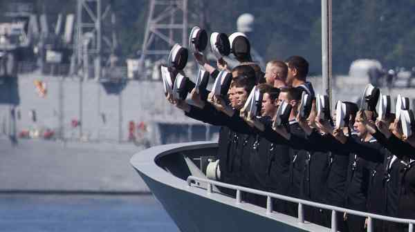 Sailors wave from the New Zealand vessel HMNZS Te Kaha. The country seeks to "ensure its interoperability" with fellow Five Eyes members the U.S., the U.K., Canada and Australia.