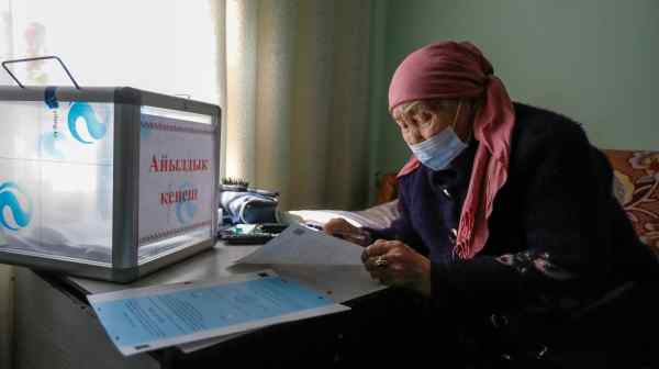 A Kyrgyz woman studies her ballot during early voting in the constitutional&nbsp;referendum in April, which slimmed down parliament. The country's voters are set to cast ballots for the third time this year.