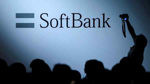 An attendee photographs the SoftBank Group logo at the SoftBank World 2017 conference in Tokyo.&nbsp;Yoshimitsu&nbsp;Goto,&nbsp;the conglomerate's chief financial officer, said on Aug. 7 that its "financial status is robust and stable," despite global market volatility.