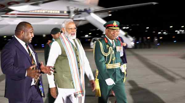 India's Prime Minister Narendra&nbsp;Modi, center, is greeted by Papua New Guinea's Prime Minister James Marape, left, late on May 21.