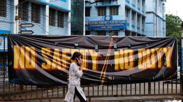 A woman passes&nbsp;a closed gate at the R.G. Kar Medical College and Hospital in Kolkata&nbsp;on Aug. 19.