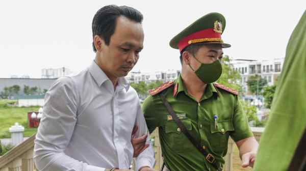 High-profile Vietnamese business tycoon Trinh Van Quyet is escorted to court on July 22 for his trial in Hanoi.