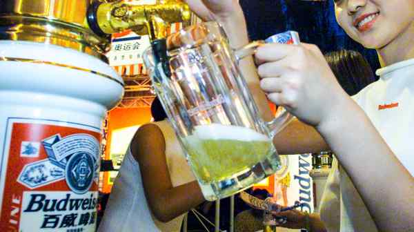 A server pours Budweiser at a beer festival in Beijing.&nbsp;Budweiser Brewing Co. APAC, the Hong Kong-listed regional arm of Anheuser-Busch InBev, has reported sharply weaker performance in the country.