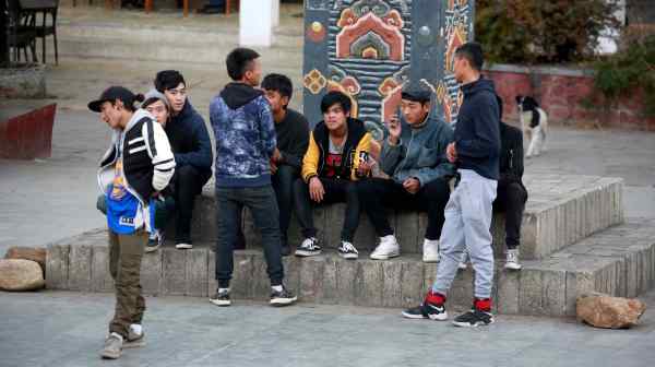 Youths sit around the central square in the capital city of Thimphu, Bhutan, in December 2017: the answer lies in hedonic adaptation.