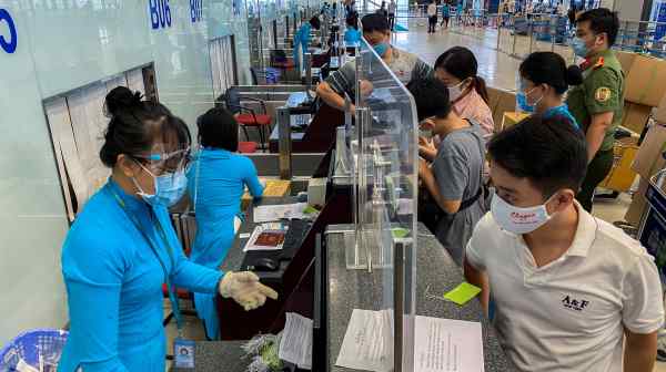 Passengers wearing protective face masks check-in at Noi Bai International Airport in Hanoi, Vietnam, in October 2021. The Vietnamese government will reopen its borders from Tuesday despite a surge in&nbsp;infections driven by the omicron variant.&nbsp;