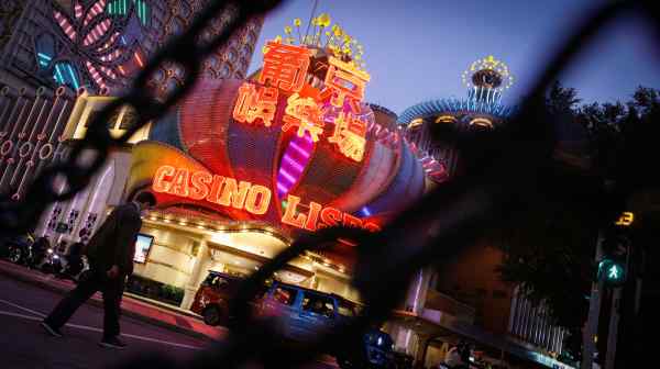 A man&nbsp;walks in front of Macao's landmark Casino Lisboa. The gambling hub's casino-dependent economy was battered by the pandemic.