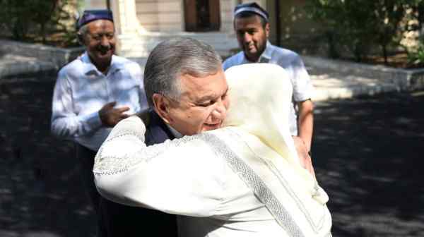 Uzbekistan's President Shavkat Mirziyoyev is greeted at a local polling station during early presidential election in Tashkent on July 9.