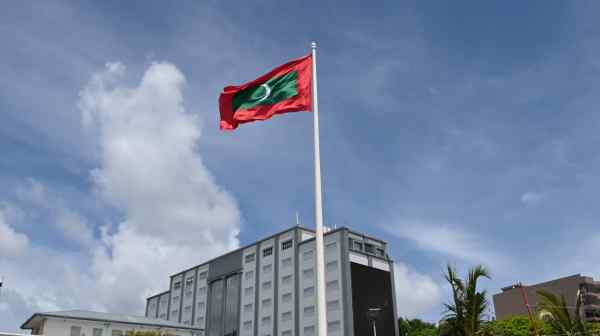 The Maldives flag flies over the capital of Male. The Indian Ocean nation is known as a tourist destination but is also a key shipping point. (Nikkei photo)