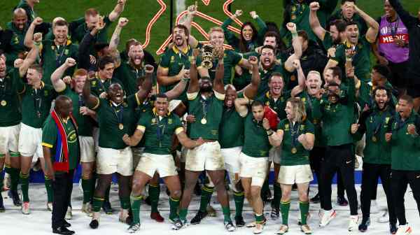 South African president Cyril Ramaphosa lifts The Webb Ellis Cup as South Africa celebrate winning the world cup final