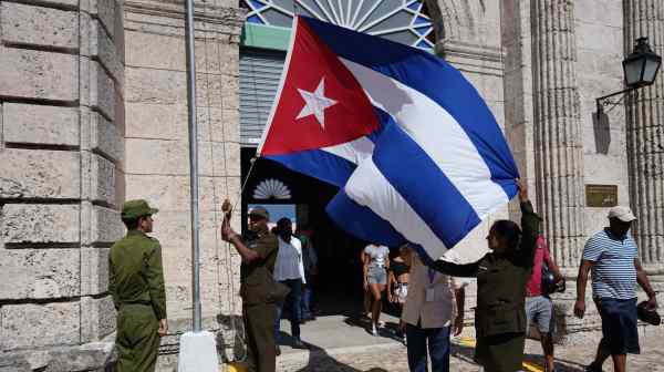 Members of the Cuban Ministry of the Interior raise their country's flag at a museum entrance in Matanzas, Cuba, in 2022. North Korea long touted its close ties with its "brother" Cuba, the only socialist nation in Latin America.