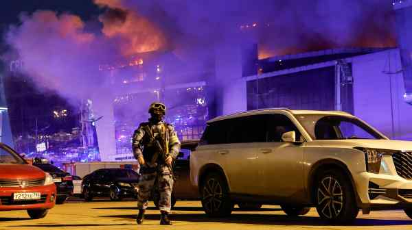 A Russian law enforcement officer near the burning Crocus City Hall concert venue following the&nbsp;attack on&nbsp;March 22.