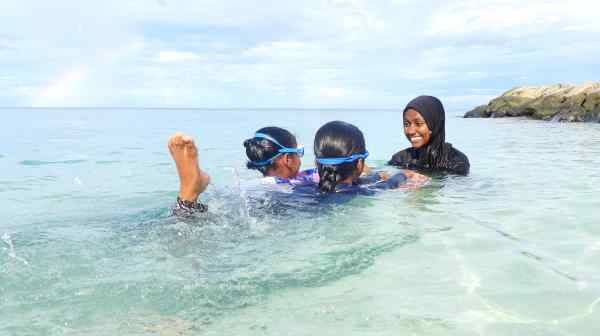 Ocean Women participant Aminath Shifza teaches two girls to swim in the waters off Rasdhoo Island as part of her instructor training. Despite being surrounded by water, many Maldivian girls face barriers to learning how to swim. (Photo by Anne Pinto-Rodrigues)