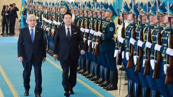 Kazakh President Kassym-Jomart Tokayev, left, and South Korean President Yoon Suk Yeol inspect&nbsp;an honor guard during a welcome&nbsp;ceremony in Astana on June 12. Yoon is on a three-nation visit to Central Asia.