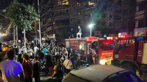 People gather near a site hit by what security sources said was a strike on Beirut's southern suburbs on July 30.