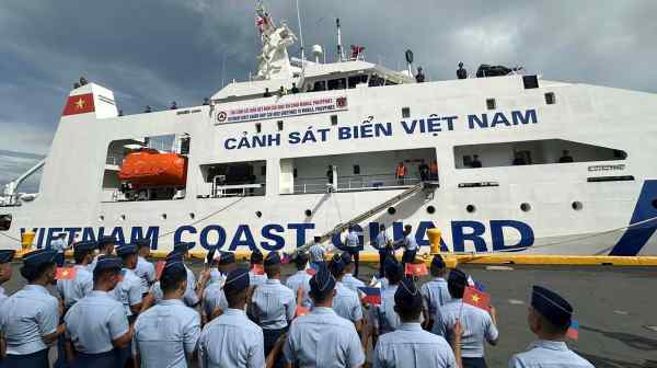 Philippine Coast Guard personnel wave Vietnamese and Filipino flags to welcome the Vietnam Coast Guard&nbsp;ship CSB 8002 in Manila on Aug. 5. Despite Hanoi and Manila holding competing claims in the South China Sea, the joint exercises are seen as a way to&nbsp;strengthen maritime cooperation amid China's aggression.