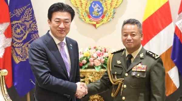 Japanese Defense Minister Minoru Kihara, left, shakes hands with his Cambodian counterpart Tea Seiha at the Defense Ministry in Phnom Penh on Aug. 5. (Cambodian Defense Ministry via AP)