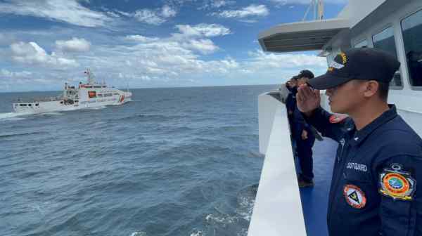 Philippine Coast Guard personnel, right, salute a Vietnam Coast Guard vessel during their joint drills conducted in Manila Bay on Aug. 9. (Photo by Ramon Royandoyan)