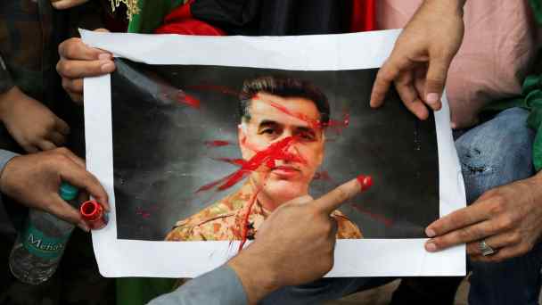 Afghans at a protest in Delhi in September 2021&nbsp;deface&nbsp;a picture of Faiz Hameed, then the head of Pakistan's Inter-Services Intelligence agency.