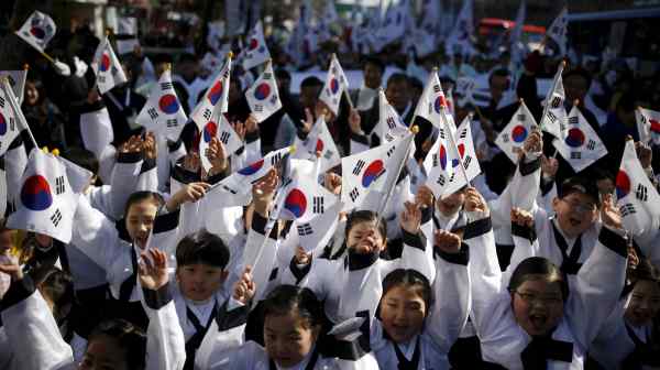 Children wearing traditional clothing wave&nbsp;national flags in Seoul. South Korea is facing&nbsp;a "national demographic emergency."