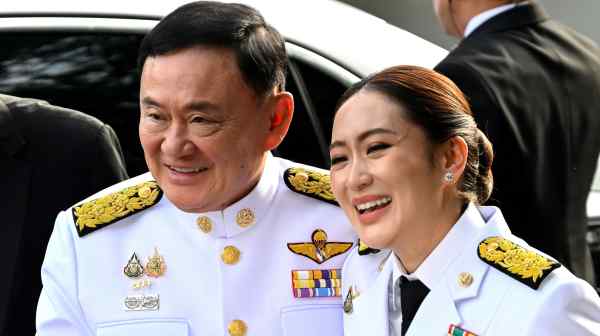 Thailand Prime Minister-elect Paetongtarn Shinawatra, right, arrives with her father and former Prime Minister Thaksin Shinawatra at the Pheu Thai party headquarters ahead of a royal endorsement ceremony in Bangkok on Aug. 18.