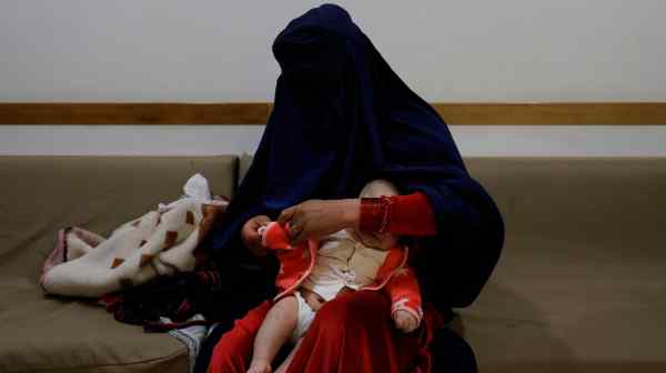 A woman dresses her child at a hospital in Bamiyan, Afghanistan, in March 2023. Since taking over in 2021, Taliban authorities have barred women from universities and most charity jobs, but they have made exemptions in the healthcare sector.