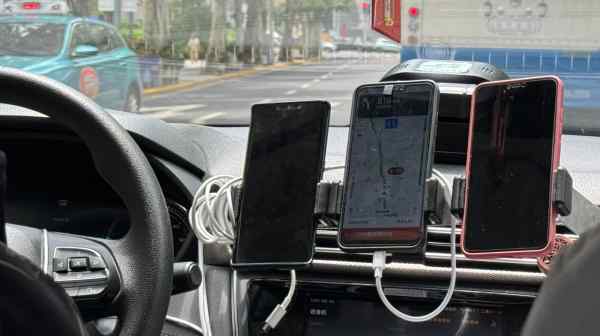 Taxi drivers need multiple smartphones to handle the various ride-hailing apps used by commuters.&nbsp;(Photo by Tomoko Wakasugi)