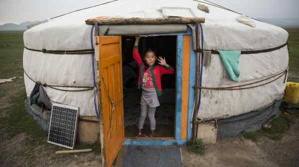 A girl stands in the doorway of her family's ger in Altanbulag, Mongolia. Her family, herders, began&nbsp;accepting guests via Airbnb in 2016.&nbsp;