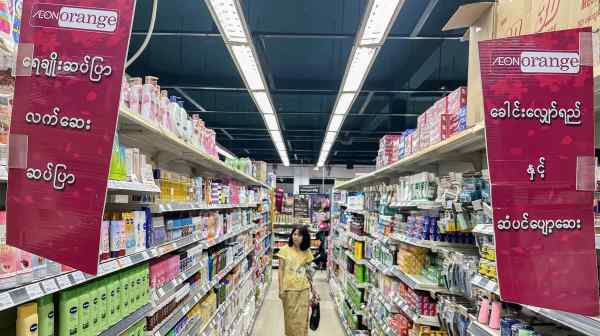 A shopper walks down an aisle at an Aeon Orange supermarket in Yangon.