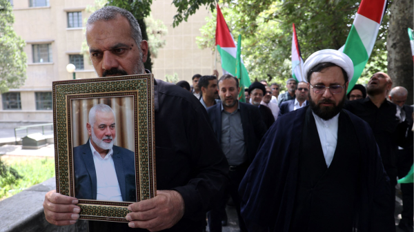 An Iranian man holds a picture of Hamas' top leader Ismail Haniyeh after he was killed in Tehran. (West Asia News Agency via Reuters)